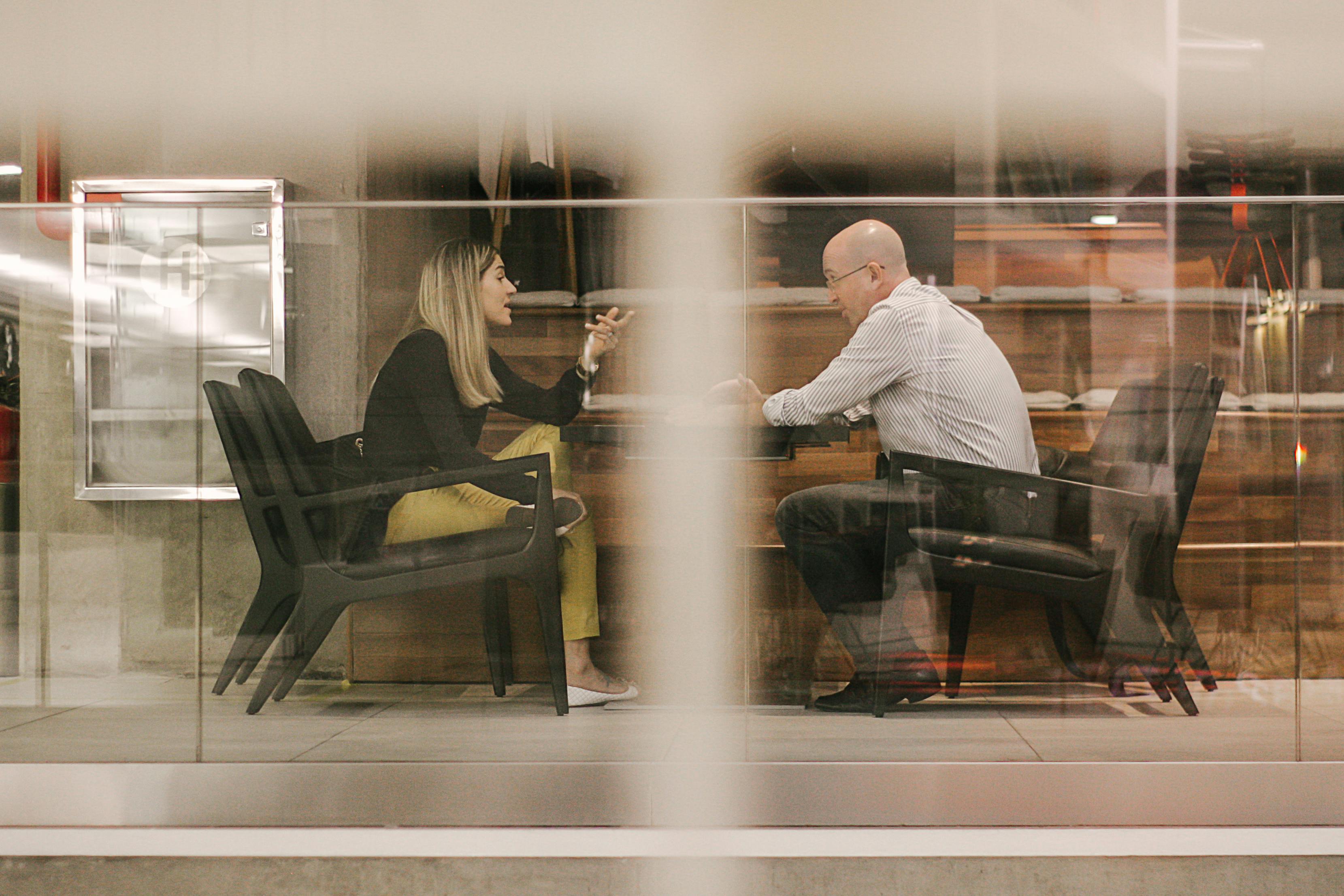 Workplace conversation through glass wall